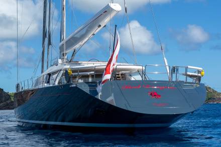 The majestic yacht Red Dragon glides through the azure waters, its sleek design a testament to maritime luxury.