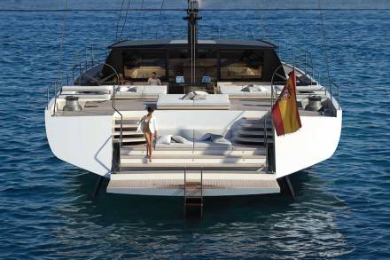 A woman in a bikini and white shirt descends the steps of a modern yacht adorned with a Spanish flag.