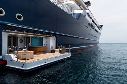 A luxurious yacht's open stern reveals a serene spa area with a jacuzzi and comfortable seating, inviting relaxation at sea.