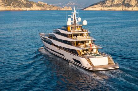 A luxurious superyacht glides through the azure waters of the Mediterranean Sea.