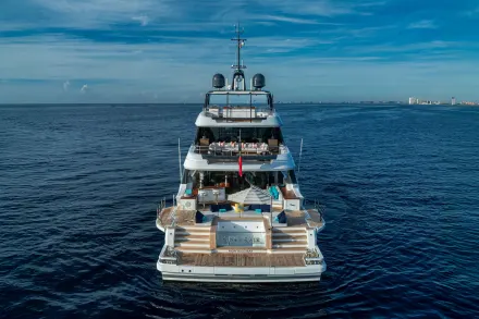 A luxurious superyacht named "King's Lair" cruises on calm blue waters under a partly cloudy sky.