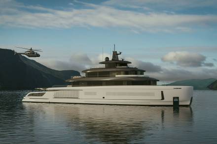 A large, luxurious yacht floating on a calm body of water, surrounded by mountains and a cloudy sky.