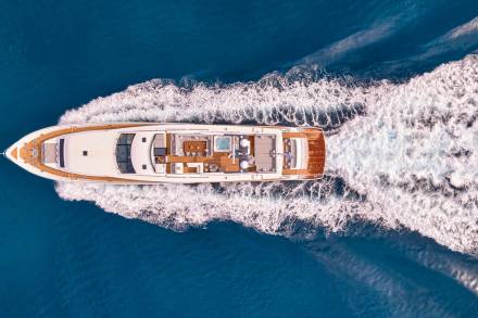 A luxurious yacht glides through the deep blue ocean, leaving a foamy wake in its path.
