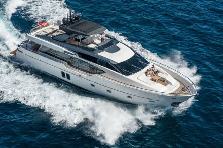 A large, luxurious yacht cutting through the deep blue waters, with a sleek and modern design and ample outdoor deck space for passengers to enjoy the scenic ocean view.
