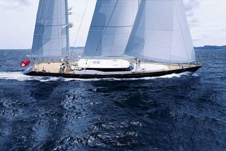 A majestic sailing yacht glides through the deep blue ocean under a cloudy sky.