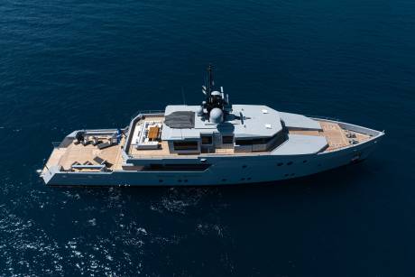 A large, luxurious yacht with a sleek, modern design sits atop the deep blue waters of the ocean, surrounded by the vast expanse of the sea.