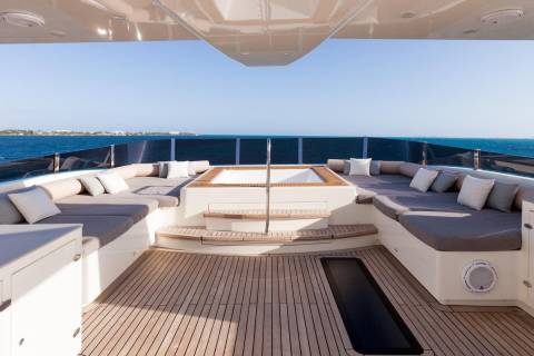Relax on the spacious sundeck of this luxury yacht, complete with plush seating and a built-in hot tub overlooking the ocean.