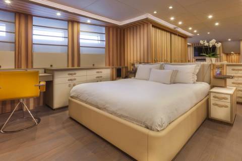 Luxurious wood paneling and a plush bed create a serene retreat aboard this elegant yacht.