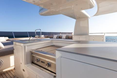 A sleek outdoor kitchen and lounge area on a yacht offers a perfect spot for al fresco dining with ocean views.