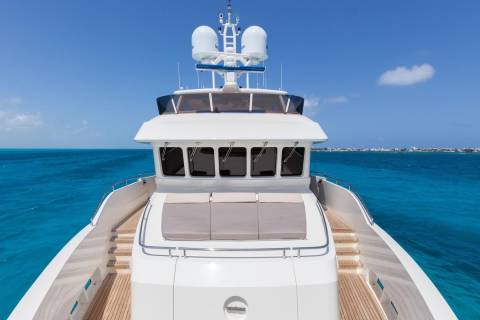 A pristine white yacht glides through the impossibly blue waters of a tropical paradise.