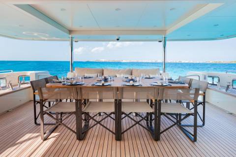 Dine al fresco on a luxury yacht's deck, surrounded by the vibrant turquoise waters of the Caribbean.