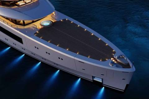 A luxurious yacht glides through dark waters, illuminated by soft deck lights and dramatic underwater blue spotlights.