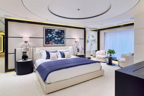 Luxurious yacht master suite features a plush king-sized bed, elegant artwork, and a serene seating area with ocean views.