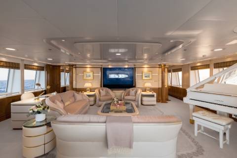 Luxurious yacht interiors offer a serene escape with plush seating, elegant decor, and a grand piano overlooking the ocean.