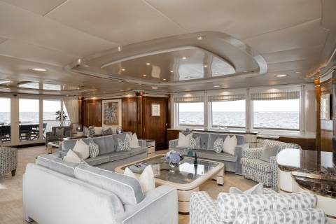Luxurious yacht interiors offer breathtaking ocean views from plush seating arrangements and elegant wood paneling.