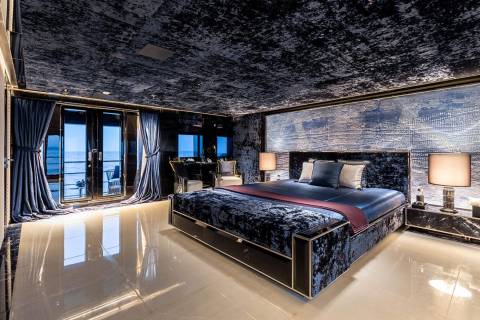Luxurious bedroom with plush velvet furnishings and stunning ocean views creates an opulent retreat.