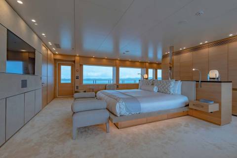 Luxurious yacht master suite offers serene ocean views from a spacious, elegantly appointed bedroom.