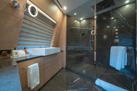 Luxurious marble and wood create a serene spa-like atmosphere in this modern yacht bathroom.