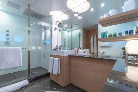 Luxurious yacht bathroom features a sleek glass shower, modern vanity with ample storage, and elegant marble flooring.