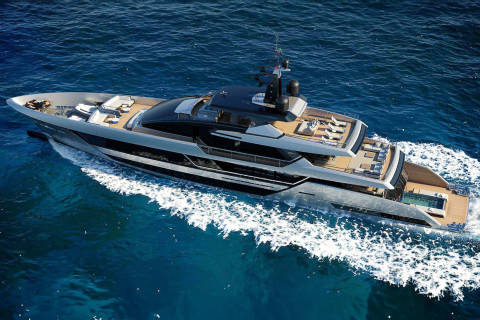 A sleek, modern yacht glides through the deep blue ocean, leaving a trail of white foam in its wake.