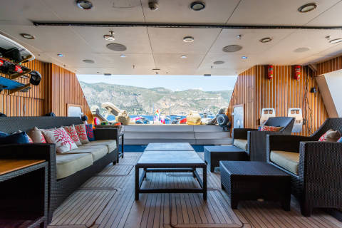 Relax on the spacious deck of this luxury yacht, surrounded by stunning coastal views and comfortable seating.