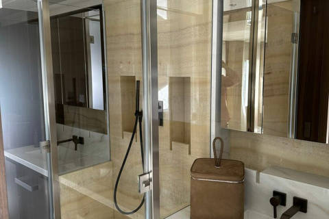 Luxurious marble and glass create a spa-like sanctuary in this modern bathroom.