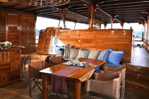 Luxurious wooden interiors and plush seating create a cozy lounge area on this elegant boat.
