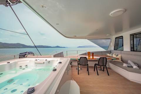 Relax in the jacuzzi or dine al fresco on the deck of this luxurious yacht with stunning ocean views.
