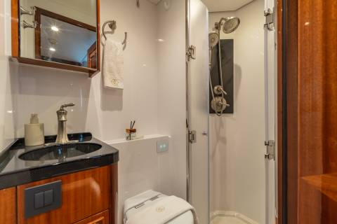 A luxurious yacht bathroom features a sleek vanity, a modern toilet, and a spacious glass-enclosed shower.