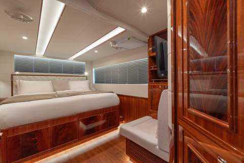 Luxurious cherry wood cabinetry and plush bedding create an opulent retreat aboard this stunning yacht.