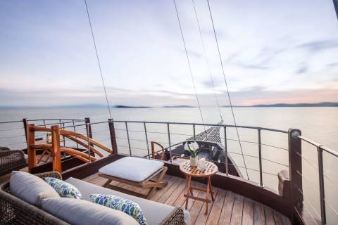 Relax on the deck of this luxurious yacht as the sun sets over the tranquil ocean.