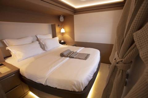 A cozy and well-appointed hotel room with a comfortable-looking bed, warm lighting, and tasteful decor.