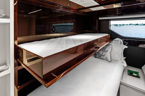 Luxurious yacht accommodations offer a serene sleeping space with a stunning ocean view.