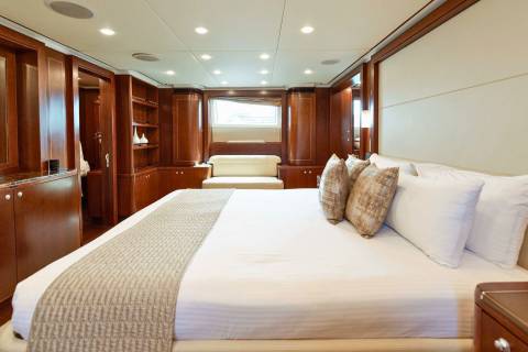 Luxurious cherry wood paneling and plush bedding create an opulent retreat aboard this elegant yacht.
