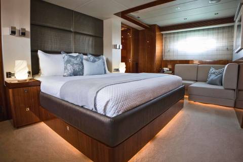 Luxurious yacht accommodations feature a plush king-sized bed, elegant headboard, and ambient lighting for ultimate comfort.