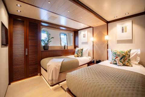 Twin beds with patterned pillows and cozy blankets await in this elegantly appointed cabin.