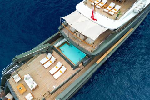 Luxurious yachts offer a serene escape with pristine pools and ample lounging space against a backdrop of deep blue waters.