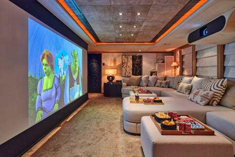 Enjoy a cinematic experience with friends and family in this luxurious home theater complete with plush seating and a large projection screen.