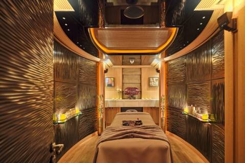 Luxurious spa treatment room features textured walls, ambient lighting, and a massage table ready for relaxation.