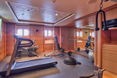 This well-equipped gym on a yacht offers a variety of machines and weights for a complete workout with a view.