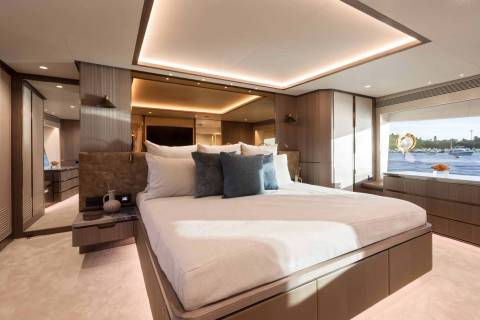 Luxurious yacht cabin offers a serene retreat with a king-sized bed and stunning waterfront views.