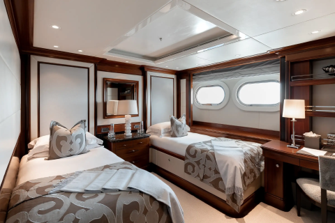 Luxurious twin beds with plush bedding and elegant decor create a serene retreat on this opulent yacht.