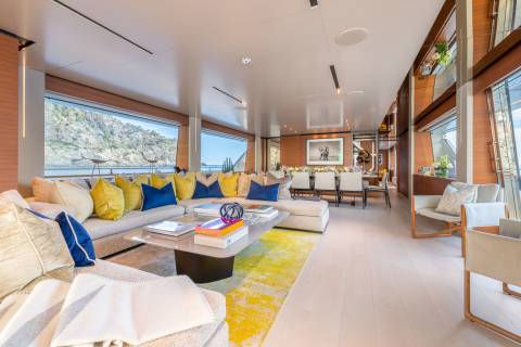 Luxurious yacht interiors offer breathtaking views of rugged coastlines and the sparkling sea.