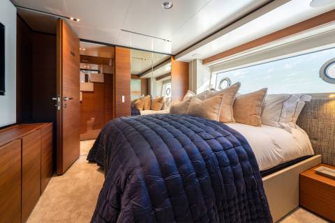 Luxurious bedding and rich wood accents create a serene sanctuary aboard this elegant yacht.