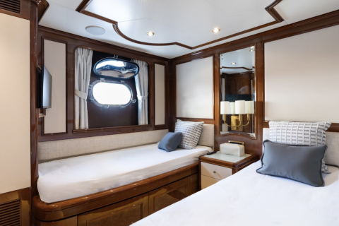 Luxurious twin beds with plush pillows offer a serene retreat within this elegantly appointed yacht cabin.