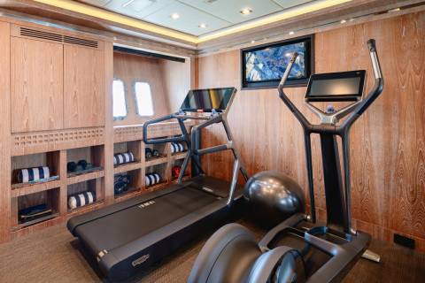 A well-equipped gym with modern cardio machines and ample storage offers a luxurious workout experience.