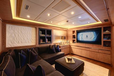 This luxurious home theater features a large screen, plush sectional sofa, and elegant wood paneling for an immersive cinematic experience.