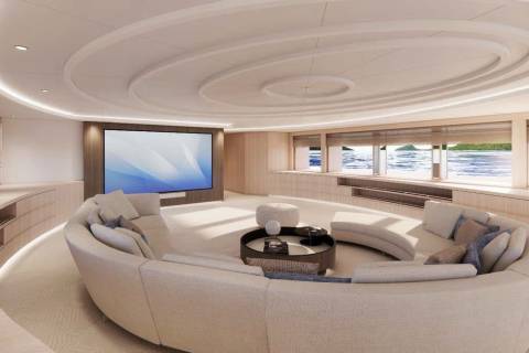 A curved sectional sofa faces a large screen in this luxurious yacht lounge with panoramic ocean views.