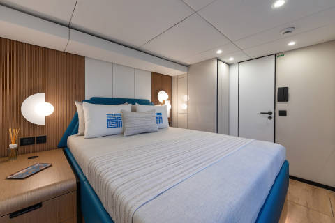 A modern and well-designed bedroom with a comfortable-looking bed, wooden accents, and a minimalist decor style.