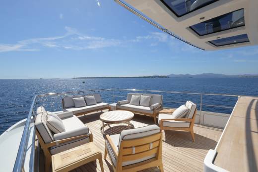 Relax on the luxurious deck of this yacht, surrounded by the sparkling blue sea and distant, hazy mountains.